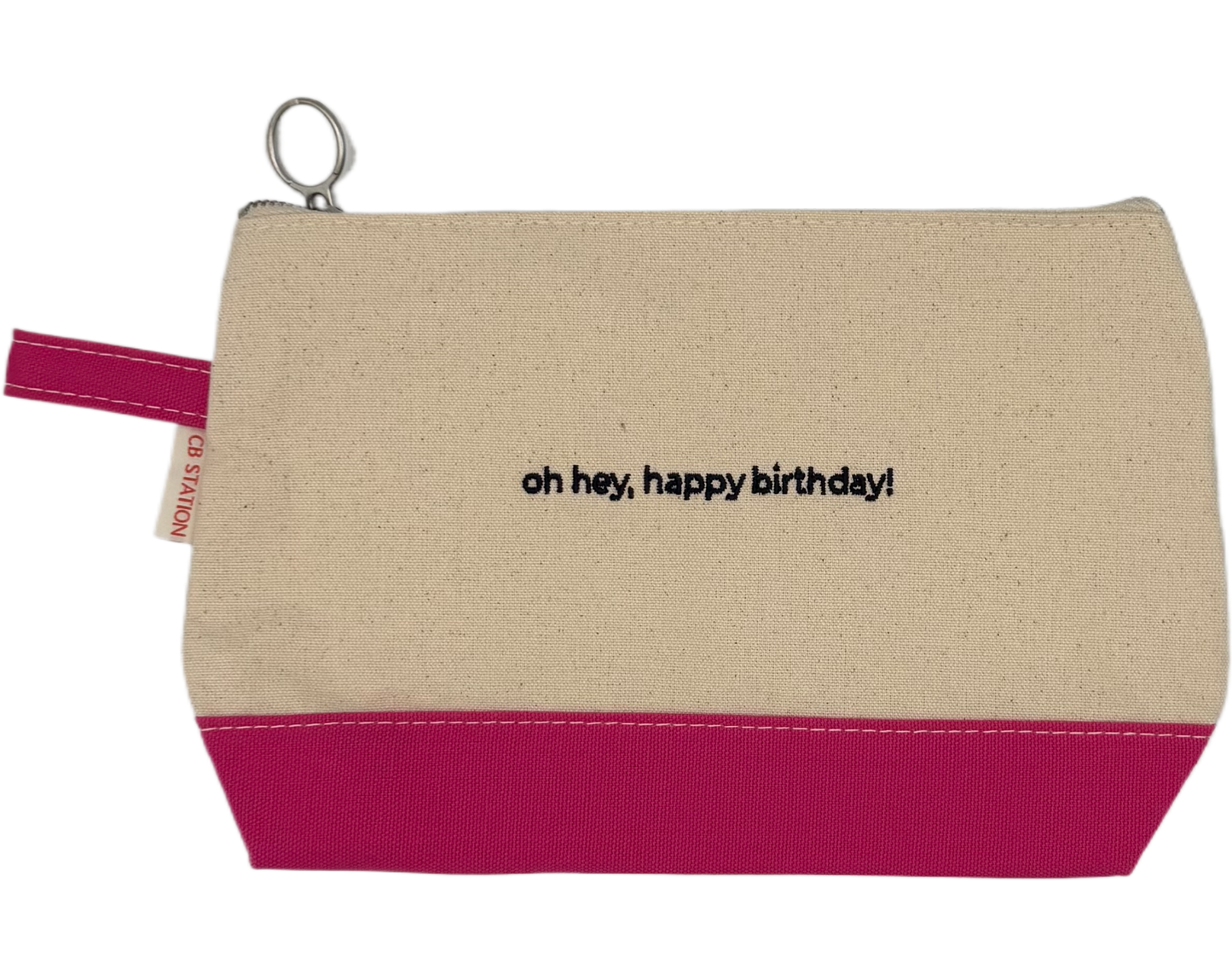 Beige pouch with pink bottom section and 'oh hey, happy birthday!' text on a white background